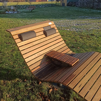 Ein höhenverstellbares Nackenkissen an einem drehbaren Waldsofa in strahlendem Sonnenschein.