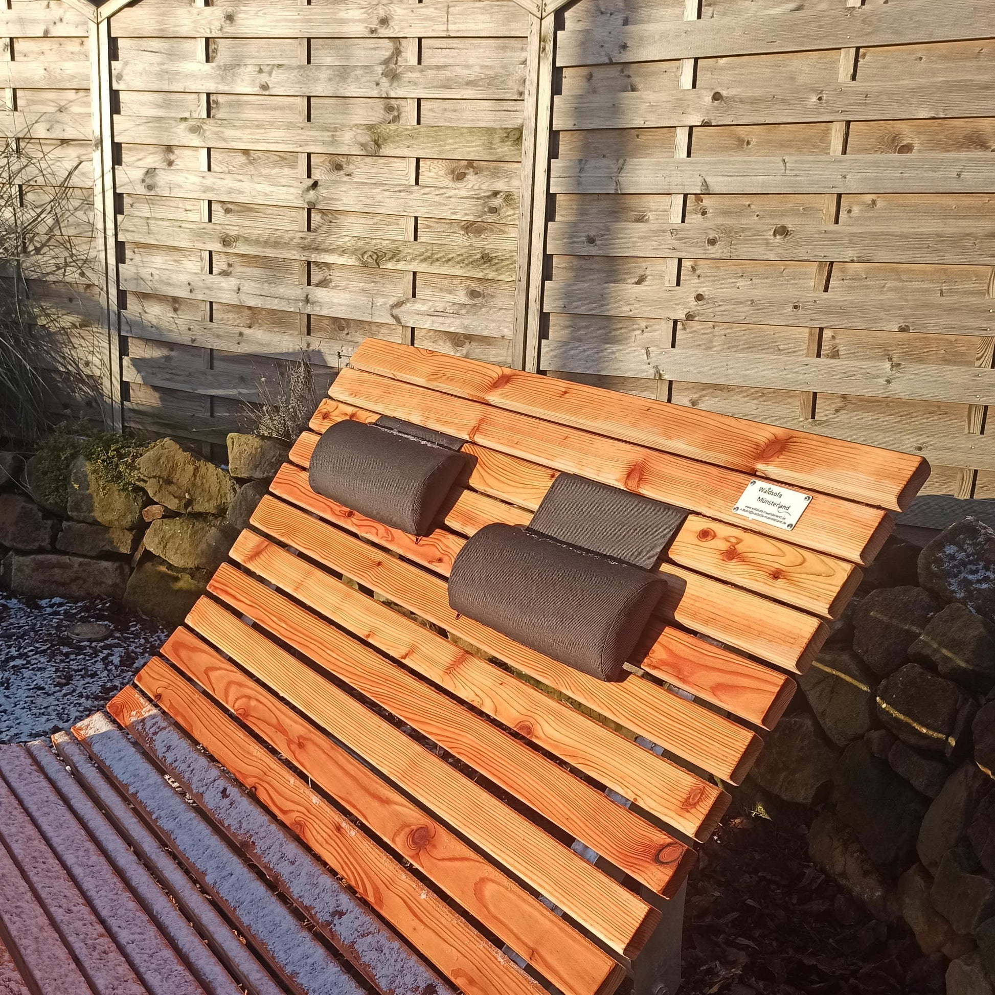 Ein höhenverstellbares Nackenkissen an einem standfestem Waldsofa in strahlendem Sonnenschein.